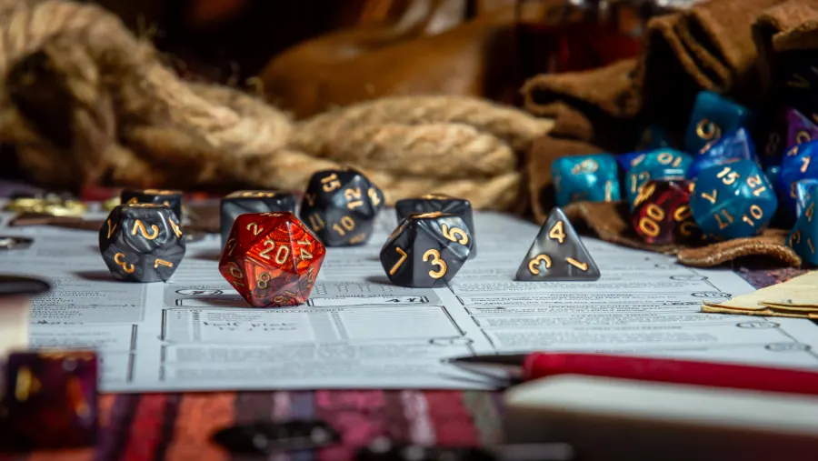 A red twenty-sided die resting on a character sheet