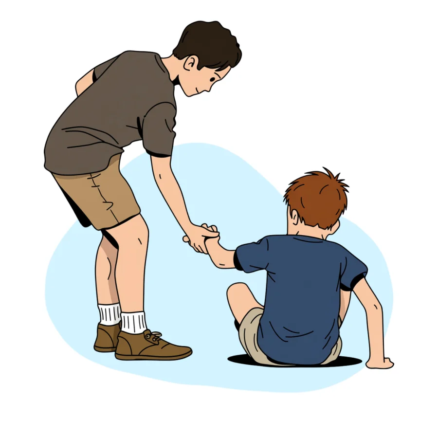 A teen reaching down to pull a younger boy up from the floor