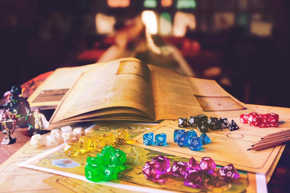 Dice, an open rulebook, a map and miniatures on a table in warm light